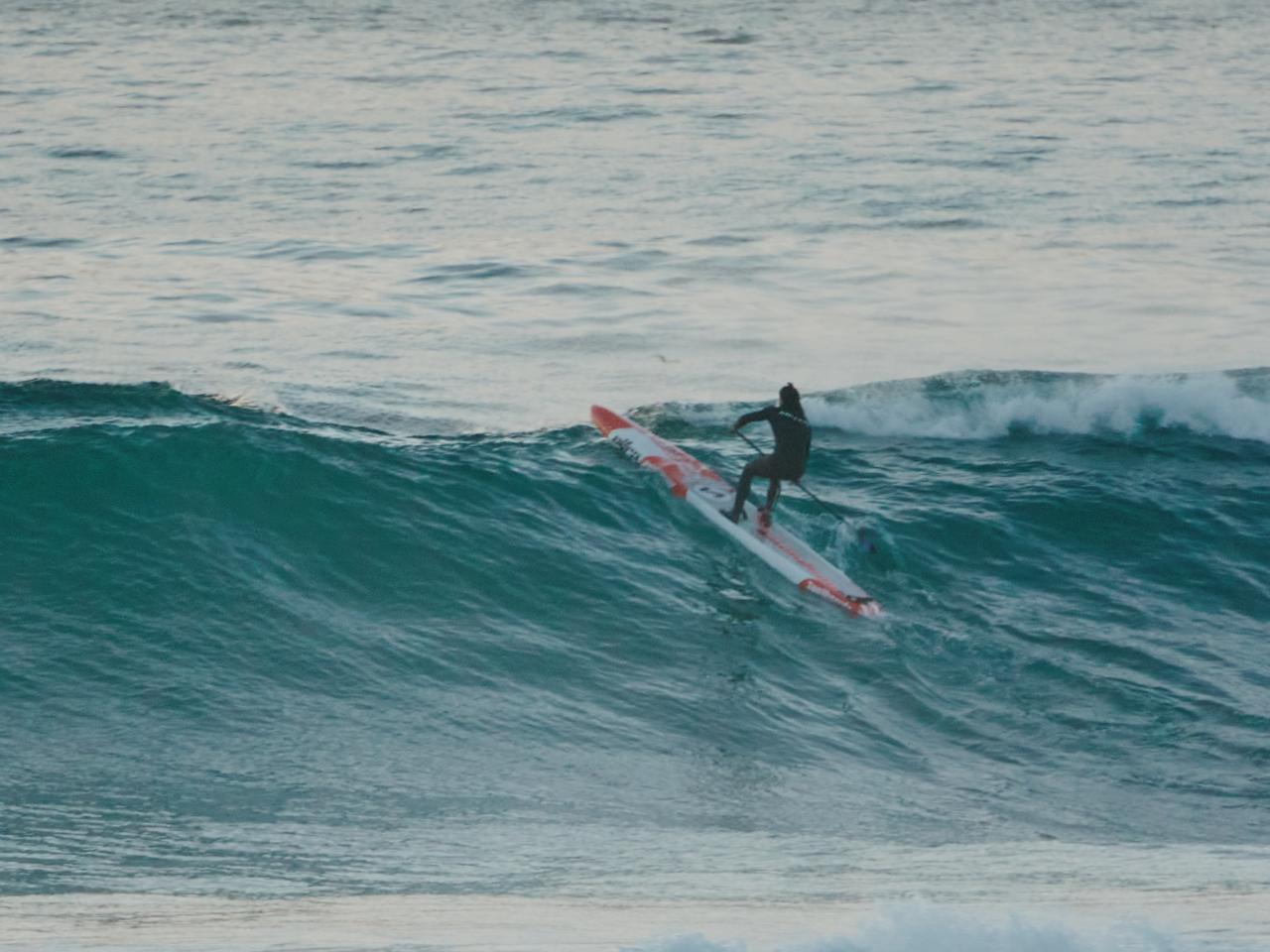 Santino surfeando una ola en el mar